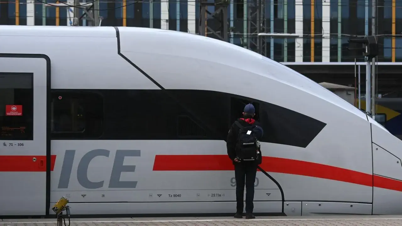 Ein Mann mit Rucksack steht vor einem ICE-Zug in Deutschland. Streiks im Bahnverkehr legen den Zugverkehr lahm.