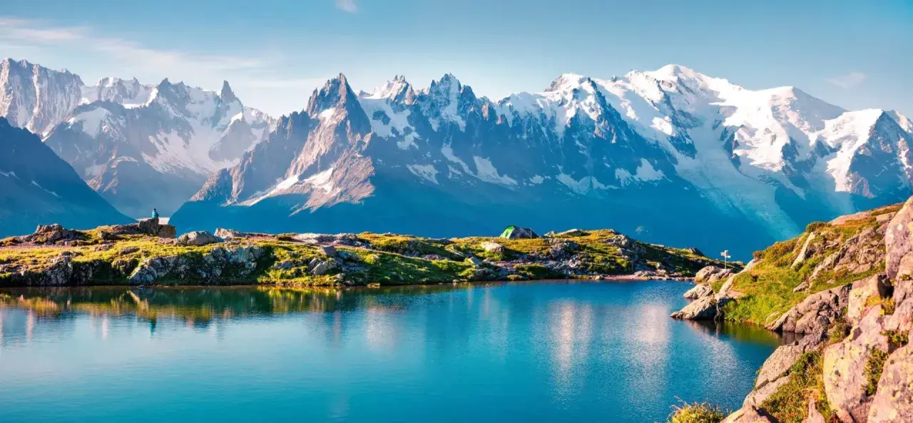 Bergsee mit Zelt und einem Wanderer, der die majestätische Mont Blanc Wanderung genießt.