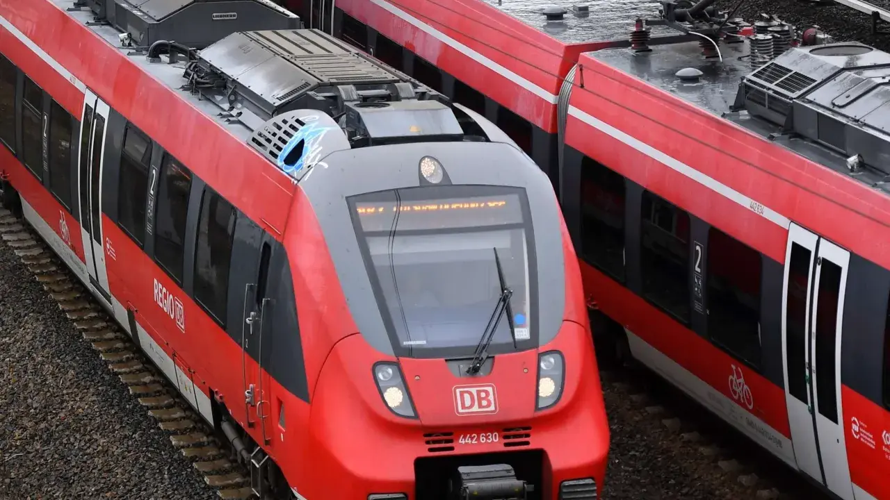 Zwei rote Regio-Züge der Deutschen Bahn stehen nebeneinander auf den Gleisen.