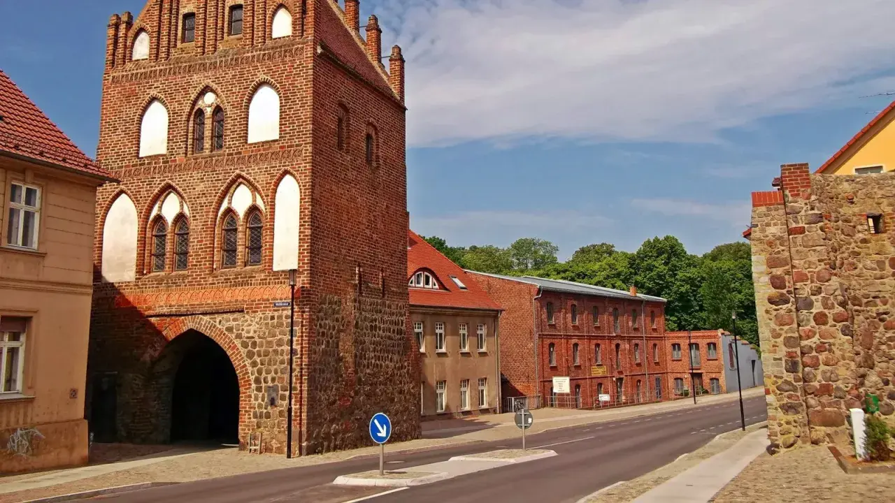 Historisches Stadttor in Templin Altstadt, mit Backstein und Feldstein erbaut, daneben rote Backsteingebäude und eine Steinmauer.
