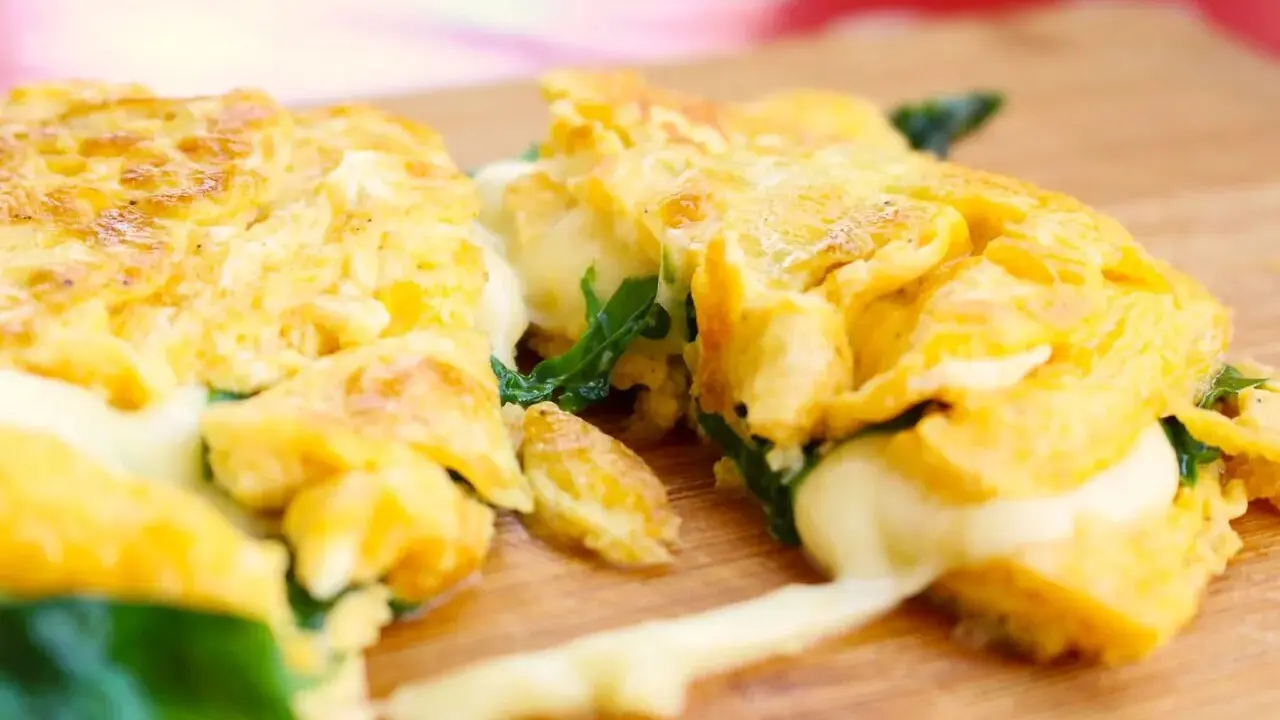 Gefülltes Omelett mit geschmolzenem Käse und Spinat, perfekt für einfache Outdoor-Gerichte.