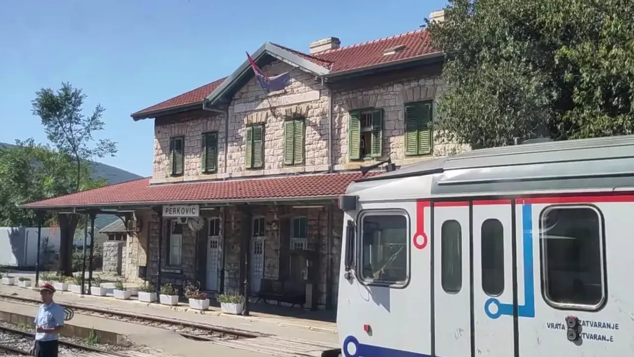 Ein Zug nach Split steht am Bahnhof Perković. Ein Schaffner wartet auf dem Bahnsteig.