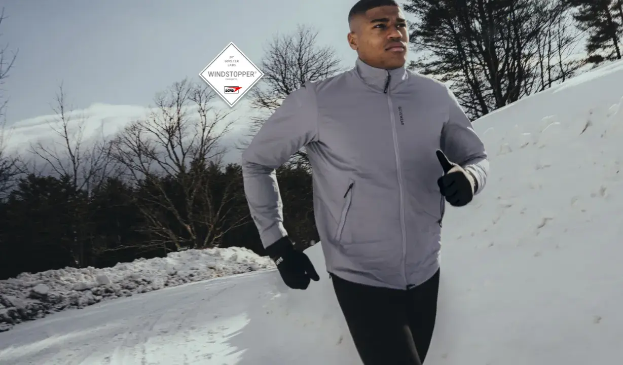 Läufer im Schnee, geschützt durch GORE-TEX INFINIUM™ WINDSTOPPER® Jacke und Handschuhe.