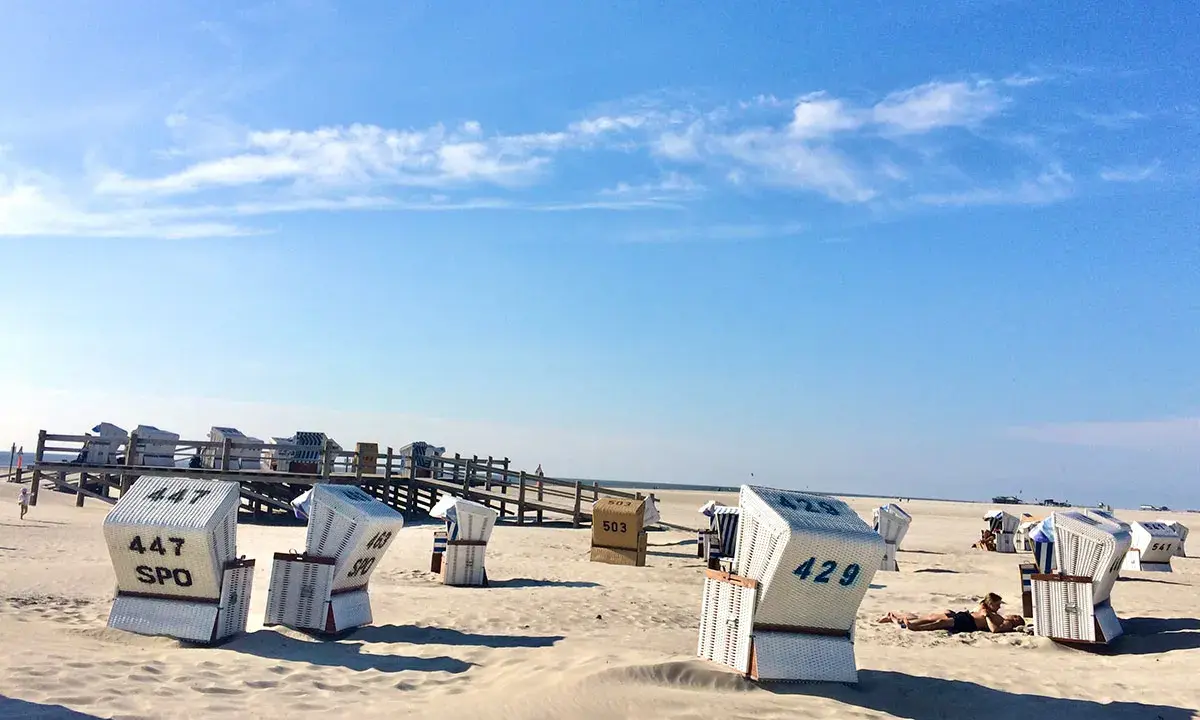 Strandkörbe am Meer, ein Geheimtipp für Sankt Peter-Ording. Sonnenschein und blauer Himmel.