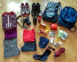 Packliste Mehrtagswanderung: Wanderschuhe, Rucksäcke, Kleidung, Kamera, Verpflegung, Trinkflasche, Sonnenbrille, Regenschirm und Wanderkarten.