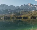Spiegelglatter See vor bewaldeten Bergen. Ein Ort, der zum Camping am Staffelsee einlädt.