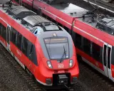 Zwei rote Regio-Züge der Deutschen Bahn stehen nebeneinander auf den Gleisen.