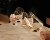Drei Gläser Weißwein werden angestoßen. Ein schöner Moment nach einem langen Wein wandern.