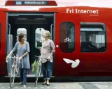 Zwei Frauen mit Fahrrädern steigen in einen roten **denmark train** nach Kopenhagen.