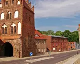 Historisches Stadttor in Templin Altstadt, mit Backstein und Feldstein erbaut, daneben rote Backsteingebäude und eine Steinmauer.