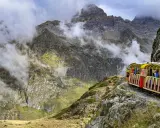Gelber Zug fährt durch neblige Berglandschaft in den Pyrenäen, Frankreich.