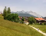 Ein Wanderweg führt durch blühende Wiesen zum malerischen Seefeld. Ein echter Geheimtipp mit Bergblick und traditioneller Architektur.