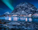 Ein malerisches Dorf in Norwegen im Winter, beleuchtet von den Nordlichtern und dem Sternenhimmel.