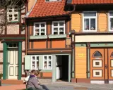 Fachwerkhäuser in Wernigerode, ein Ort voller geheimtipps. Zwei Personen sitzen auf einer Bank vor bunten Häusern.