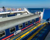 Ein blauer Nachtzug nach Palermo steht auf einer Fähre. Ein Mann blickt aufs Meer.