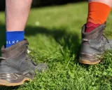 Falke TK1, TK2, TK3, TK4 Socken in Blau und Orange, getragen mit Wanderschuhen im Gras.