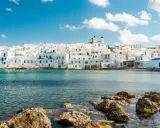 Weiße Häuser mit blauen Akzenten am Meer, ein Traumziel für beste Urlaubsziele.