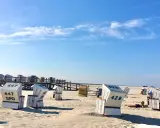 Strandkörbe am Meer, ein Geheimtipp für Sankt Peter-Ording. Sonnenschein und blauer Himmel.