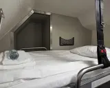 Gemütliches Bett im Schlafwagen, bereit für die Reise mit dem Santa Claus Express. Mit Handtüchern und Wasserflasche.