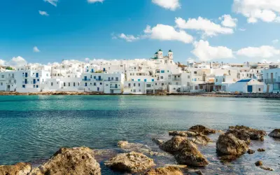 Weiße Häuser mit blauen Akzenten am Meer, ein Traumziel für beste Urlaubsziele.
