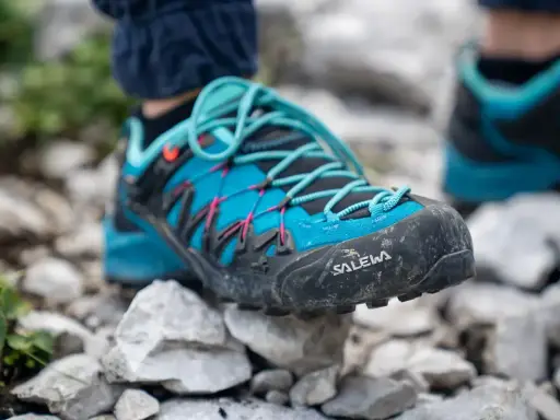 Blaue Salewa Wanderschuhe mit türkisen Schnürsenkeln, bereit für jedes Abenteuer auf steinigem Untergrund.