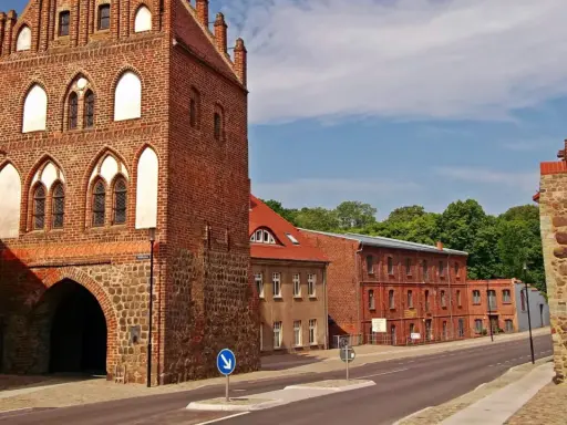 Historisches Stadttor in Templin Altstadt, mit Backstein und Feldstein erbaut, daneben rote Backsteingebäude und eine Steinmauer.