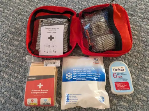 Erste Hilfe Set für das Wandern: Notfalldecke, Kühlpacks, Blasenpflaster und ein Erste-Hilfe-Kit von Forclaz.