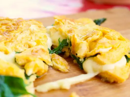 Gefülltes Omelett mit geschmolzenem Käse und Spinat, perfekt für einfache Outdoor-Gerichte.