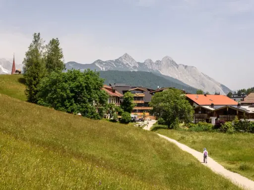 Ein Wanderweg führt durch blühende Wiesen zum malerischen Seefeld. Ein echter Geheimtipp mit Bergblick und traditioneller Architektur.
