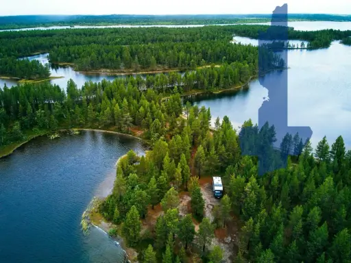 Ein Wohnmobil steht am Ufer eines Sees inmitten dichter Wälder. Perfekt für wildcampen Finnland!