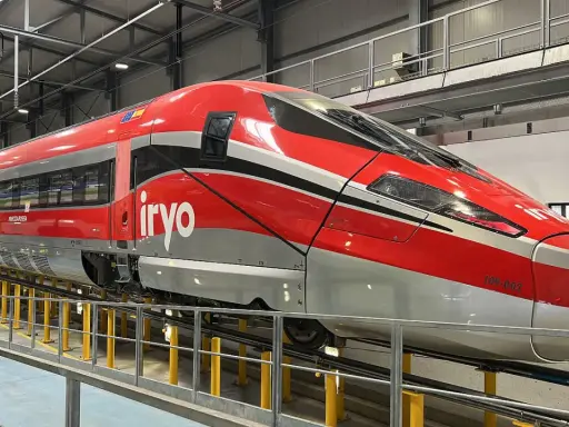 Der rote italienische Schnellzug "Frecciarossa" mit dem Logo "iryo" steht in einer Werkstatthalle.