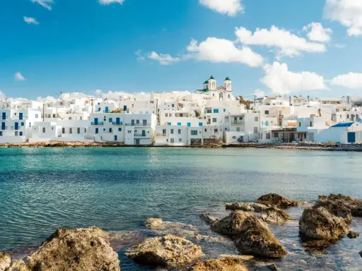 Weiße Häuser mit blauen Akzenten am Meer, ein Traumziel für beste Urlaubsziele.