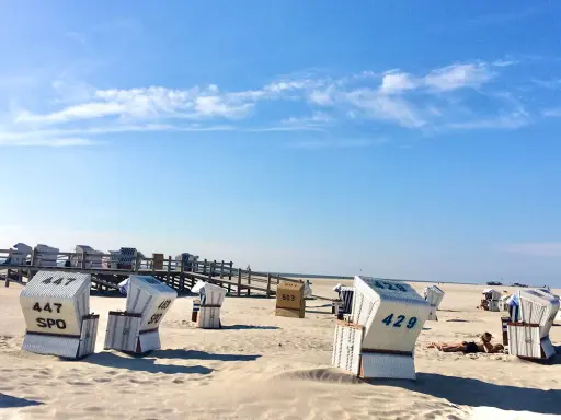Strandkörbe am Meer, ein Geheimtipp für Sankt Peter-Ording. Sonnenschein und blauer Himmel.