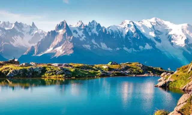 Bergsee mit Zelt und einem Wanderer, der die majestätische Mont Blanc Wanderung genießt.