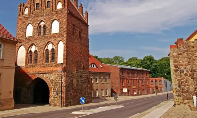 Historisches Stadttor in Templin Altstadt, mit Backstein und Feldstein erbaut, daneben rote Backsteingebäude und eine Steinmauer.