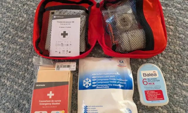 Erste Hilfe Set für das Wandern: Notfalldecke, Kühlpacks, Blasenpflaster und ein Erste-Hilfe-Kit von Forclaz.