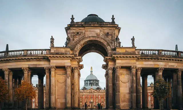 Prachtvoller Torbogen mit Blick auf das Neue Palais in Potsdam. Ein toller Ort, um zu entdecken, was man in Potsdam machen kann.