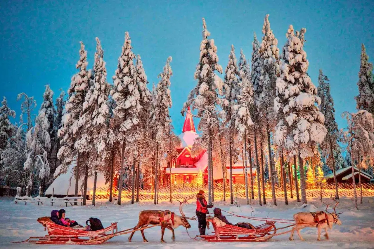 Schneebedeckte Bäume, ein rotes Gebäude mit Turm und Schlittenfahrten mit Rentieren – der Santa Claus Express ist bereit für seine Reise.