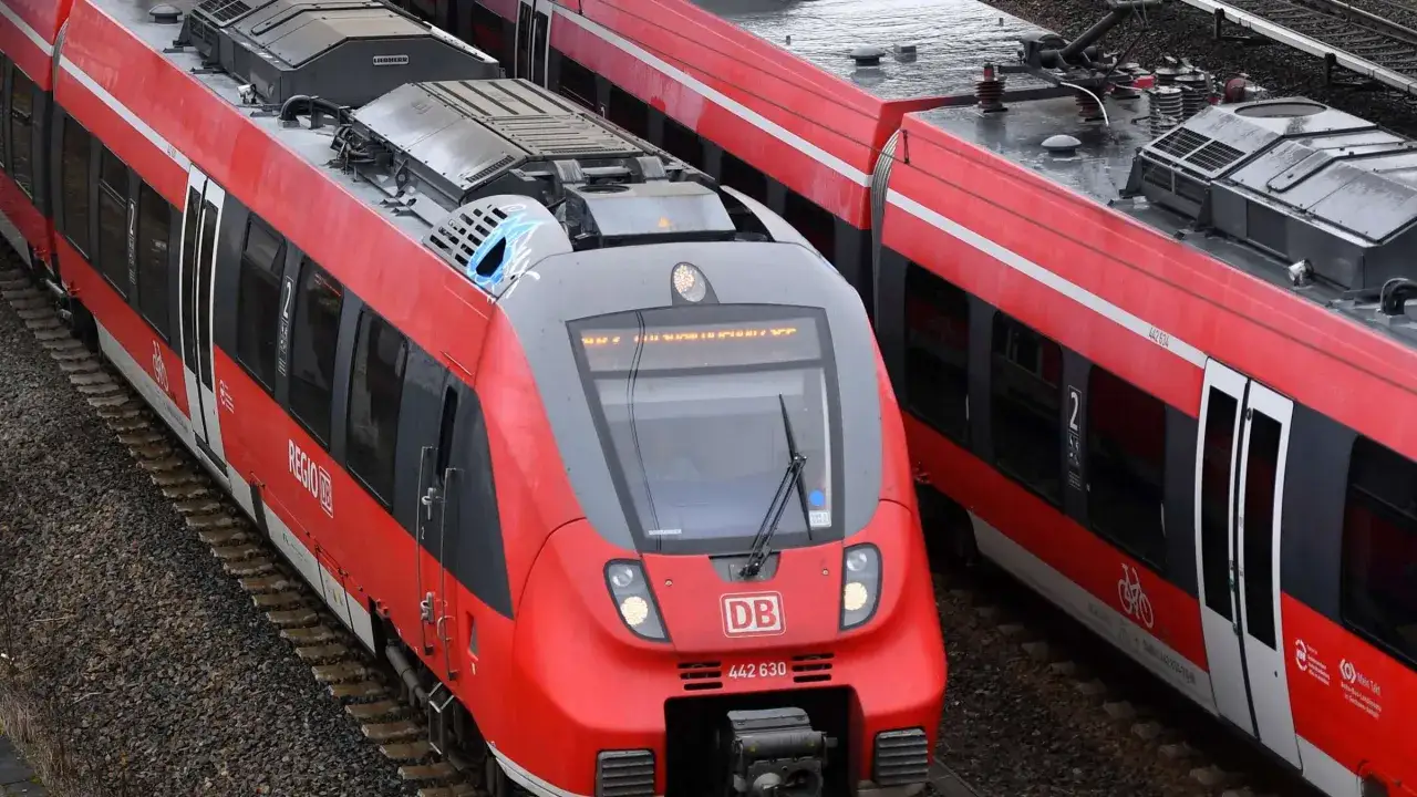 Zwei rote Regio-Züge der Deutschen Bahn stehen nebeneinander auf den Gleisen.