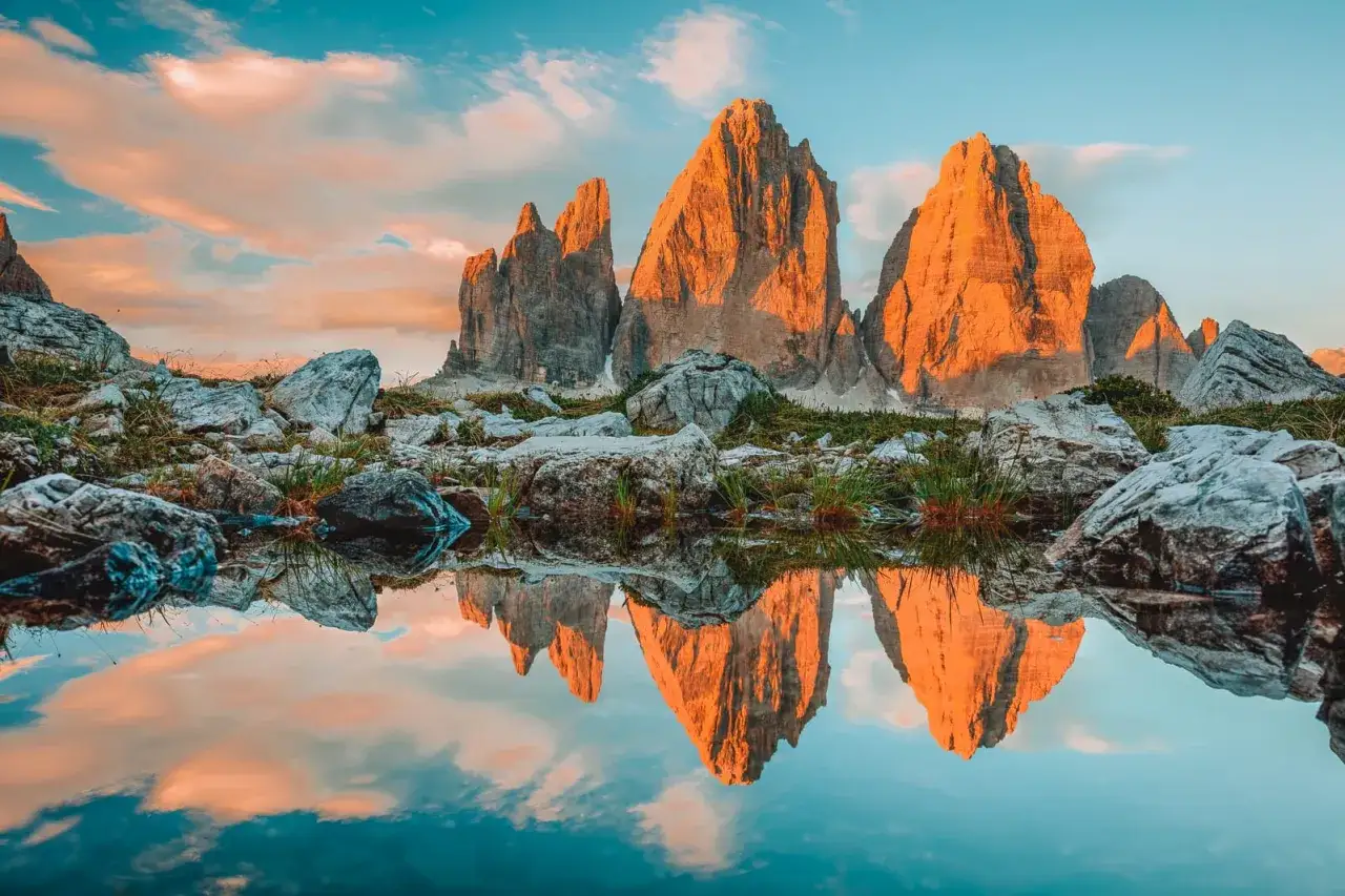 Sonnenuntergang in den Dolomiten. Ein perfekter Moment f&uuml;r Backpacking in Italien, mit den Drei Zinnen, die sich in einem Bergsee spiegeln.