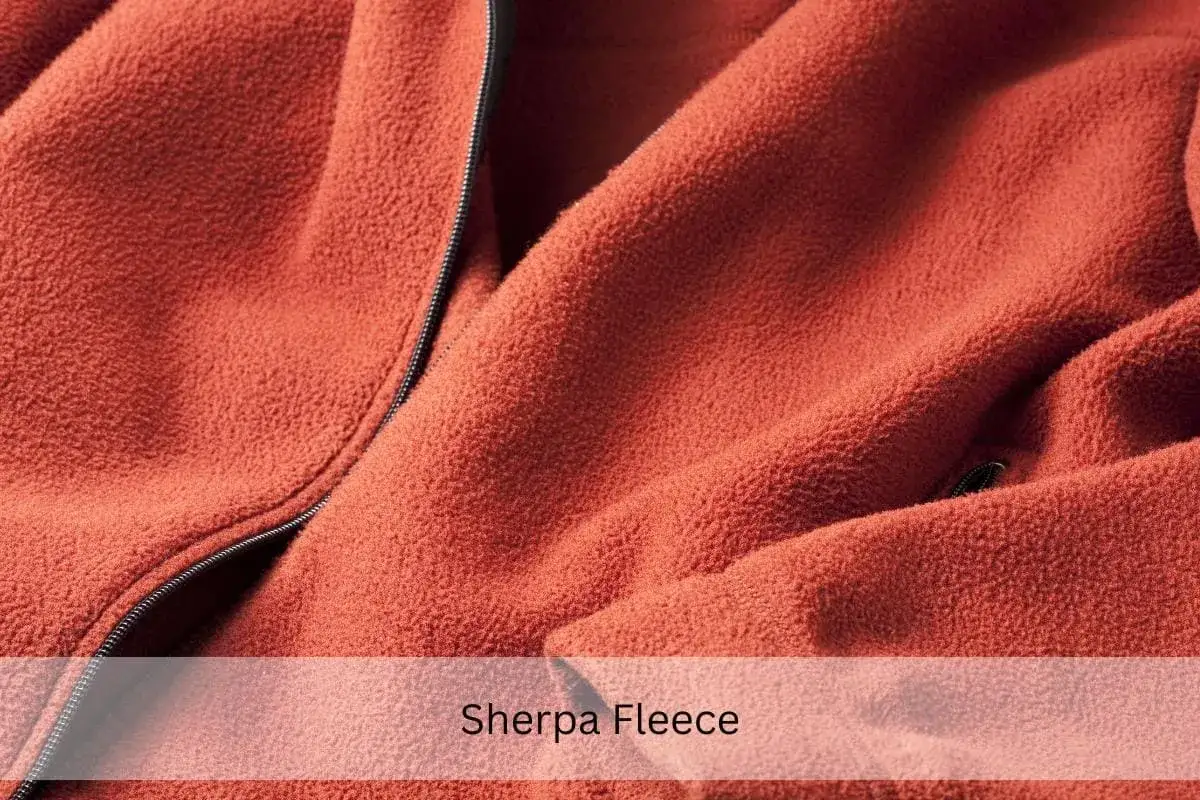 Nahaufnahme einer orangefarbenen Sherpa Fleecejacke mit Reißverschluss. Perfekt zum fleecejacke waschen.