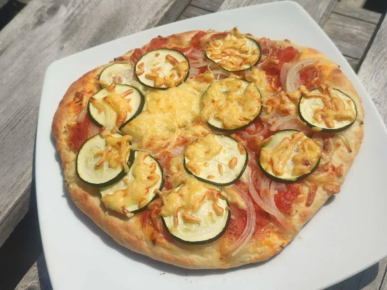 Leckere Pizza mit Zucchini und Käse, perfekt für Camping-Rezepte mit dem Gaskocher.