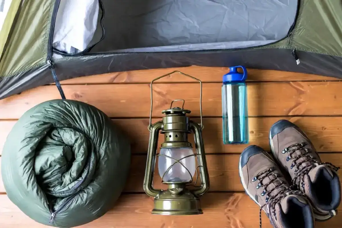Zelten was braucht man: Schlafsack, Laterne, Wasserflasche und Wanderschuhe. Alles f&uuml;r ein Abenteuer in der Natur.