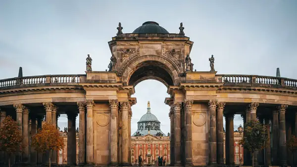 Prachtvoller Torbogen mit Blick auf das Neue Palais in Potsdam. Ein toller Ort, um zu entdecken, was man in Potsdam machen kann.